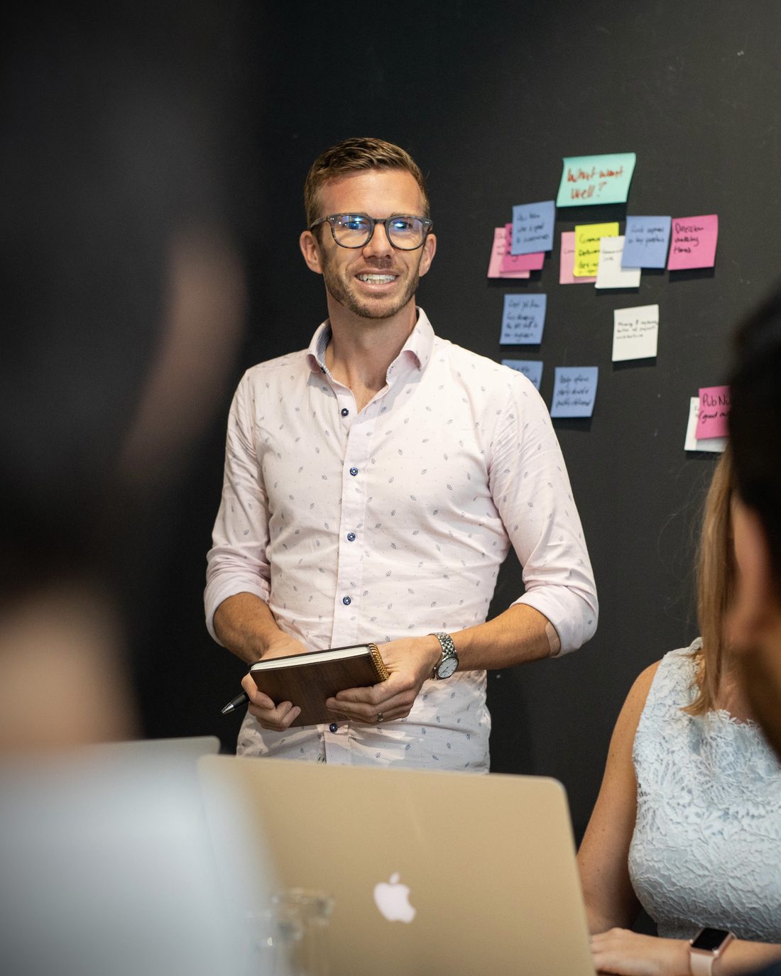 Hayden Judd presenting to a team in front of a wall of sticky notes